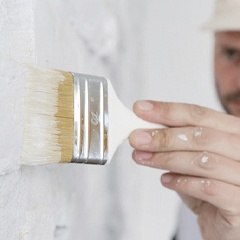 man painting brick white