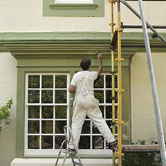 Man on scaffold painting exterior