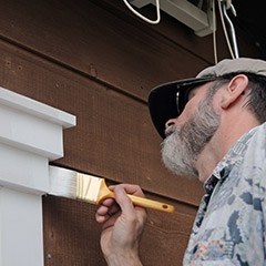 Man painting house trim