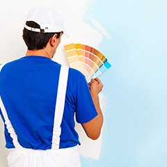 Team member displaying paint samples in front of wall