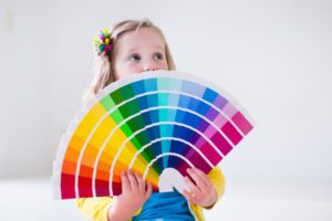 child holding color swatches for painting a kid’s room