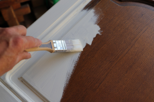 a person painting their kitchen cabinets 