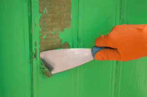 a person scraping old paint