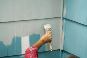 a person painting a home exterior